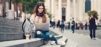 Woman on laptop on some stairs